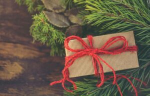 Cadeau de Noël emballé à côté d'un sapin